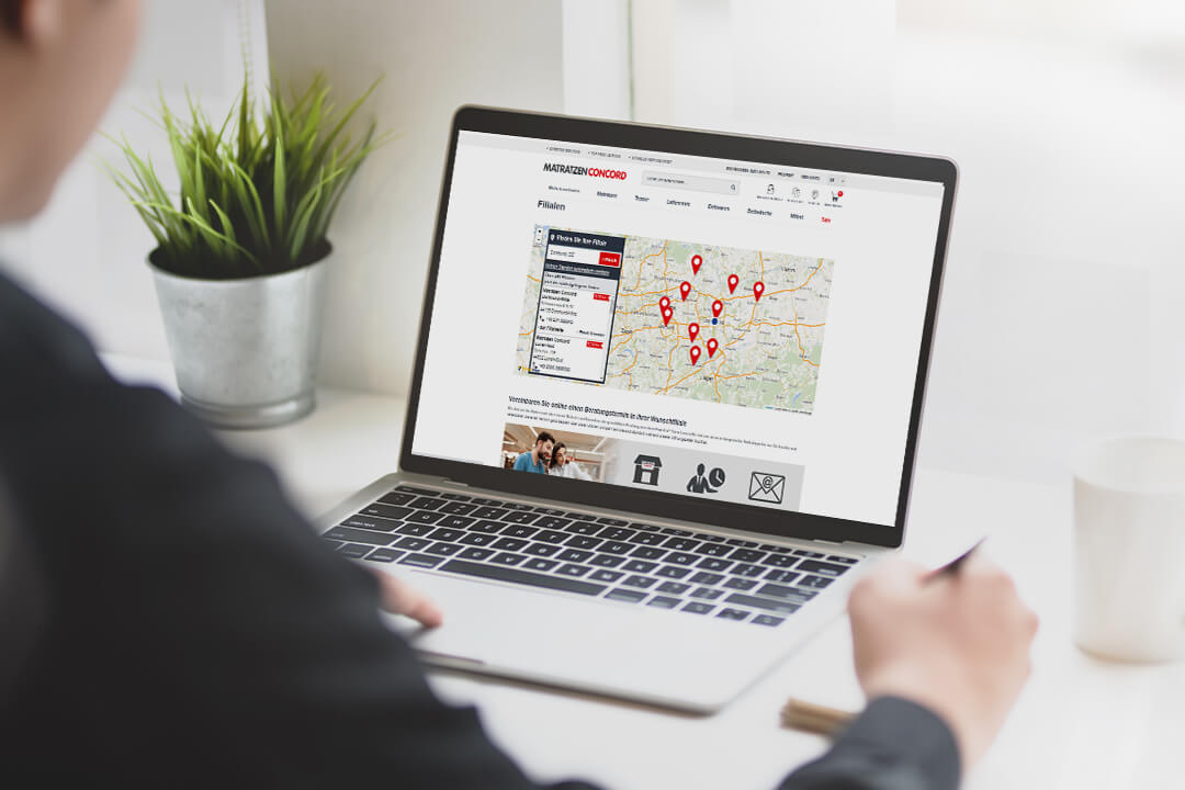 Eine Person an einem Laptop nutzt den Store Locator des Unternehmens Matratzen Concord, der mit SmartMaps umgesetzt wurde.