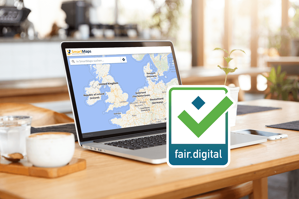 Laptop auf einem Schreibtisch, mit einem Standard Store Locator von SmartMaps. Die Karte zeigt einen Ausschnitt von Nordeuropa. Zudem ist das Gütesiegel fair.digital sichtbar.