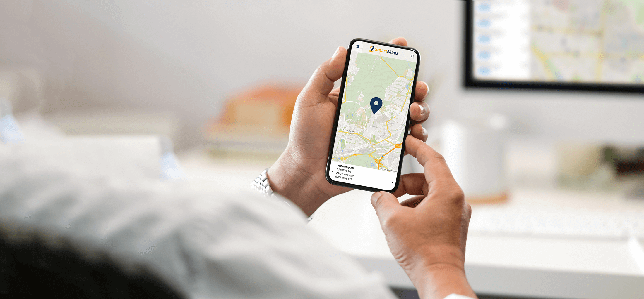 Ein Mann nutzt eine SmartMaps Standortkarte auf einem mobilen Endgerät. Darauf wird der Standort der YellowMap AG angezeigt.