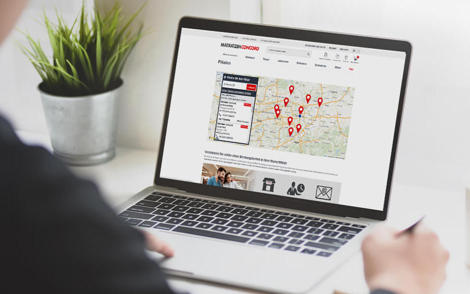 Eine Person an einem Laptop nutzt den Store Locator des Unternehmens Matratzen Concord, der mit SmartMaps umgesetzt wurde.